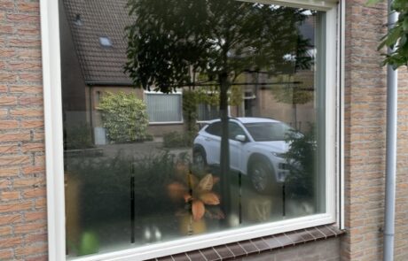 In wit uitgevoerd zonnescreen aan traditionele tussenwoning in open, niet in gebruik stand